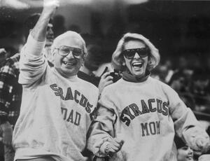 A Syracuse students mom and dad support the football team during the 1987 Parents Weekend game. In 1957, students coordinated to create the sign to at the game held in Archbold Stadium. The 1963 breakfast was held in Sims Dining Hall, which no longer exist, with Chancellor William Tolley.