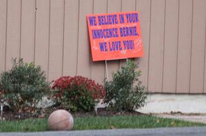 A sign expressing support for Bernie Fine rests alongside the Fine home.