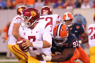 USC Trojans quarterback Matt Barkley #7 is grabbed by Syracuse Orange defensive end Brandon Sharpe #91