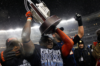 Siriki Diabate holds up the Pinstipe Bowl trophy to the fans. 