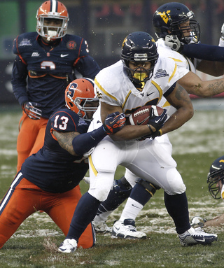 Deon Goggins #13, a tackle for Syracuse, makes a tackle behind the line of scrimmage.  Syracuse takes on West Virginia in the 2012 Pinstripe Bowl at a snowy Yankee Stadium on Saturday, December 29, 2012 in New York, New York.