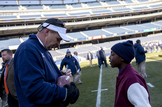 Head coach Doug Marrone signs an autograph.