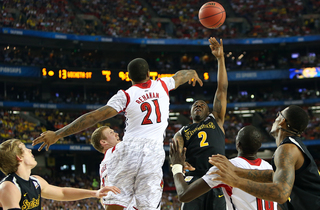 Malcolm Armstead #2 of the Wichita State Shockers puts the ball up to the basket against Chane Behanan #21 of the Louisville Cardinals.