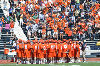 Syracuse gathers as a team near its bench before retaking the field.